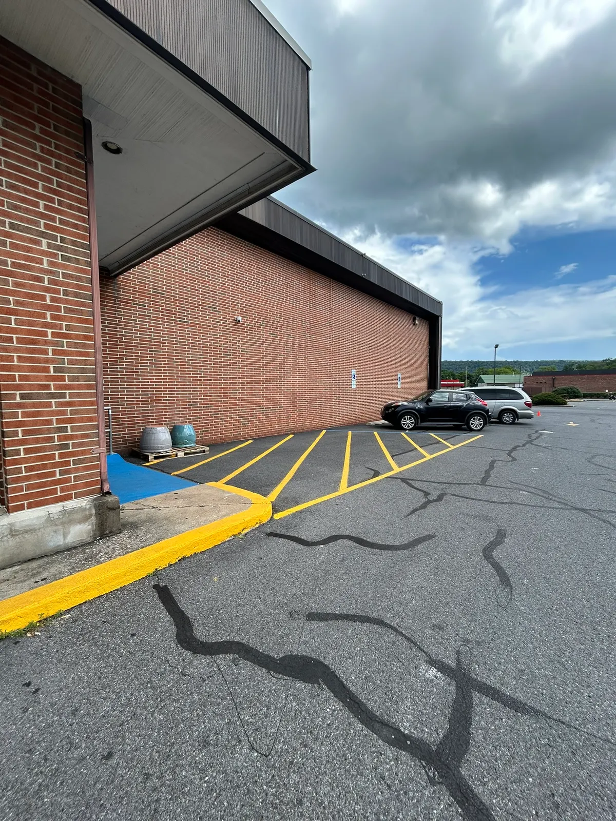 Yellow ADA access aisle striping beside a brick commercial building
