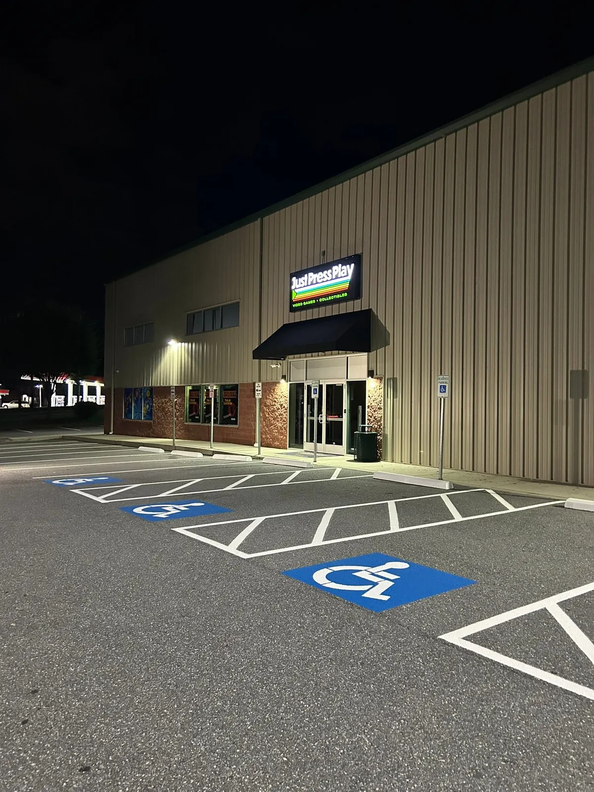 Blue ADA symbols and hatched access aisles painted at night
