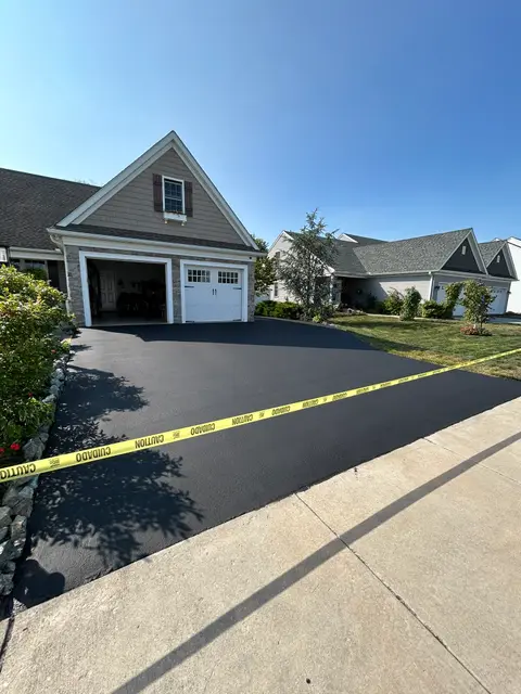 Sealcoated driveway with caution tape marking the curing zone