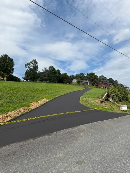Sealcoated driveway with a clean hand-cut edge along the grass