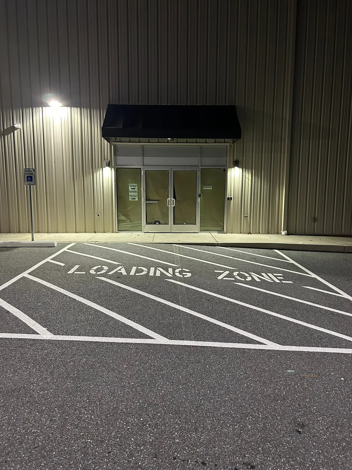 Loading zone stencil and diagonal hatching in front of a commercial entrance