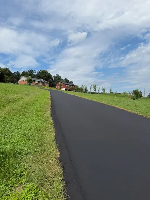 Long hillside driveway sealcoated with a crisp grass edge
