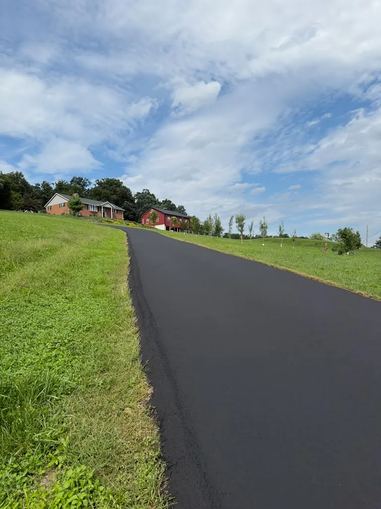 Long hillside driveway sealcoated with a crisp grass edge