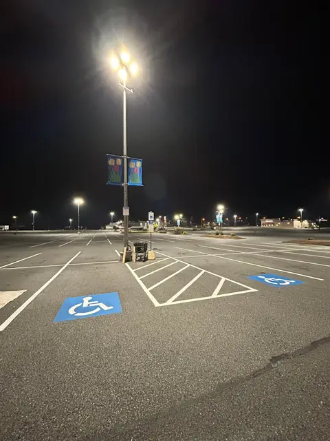 Blue ADA symbol and hatching on a lot lit by street lights
