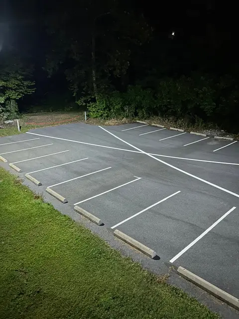White parking stalls with wheel stops beside a lawn