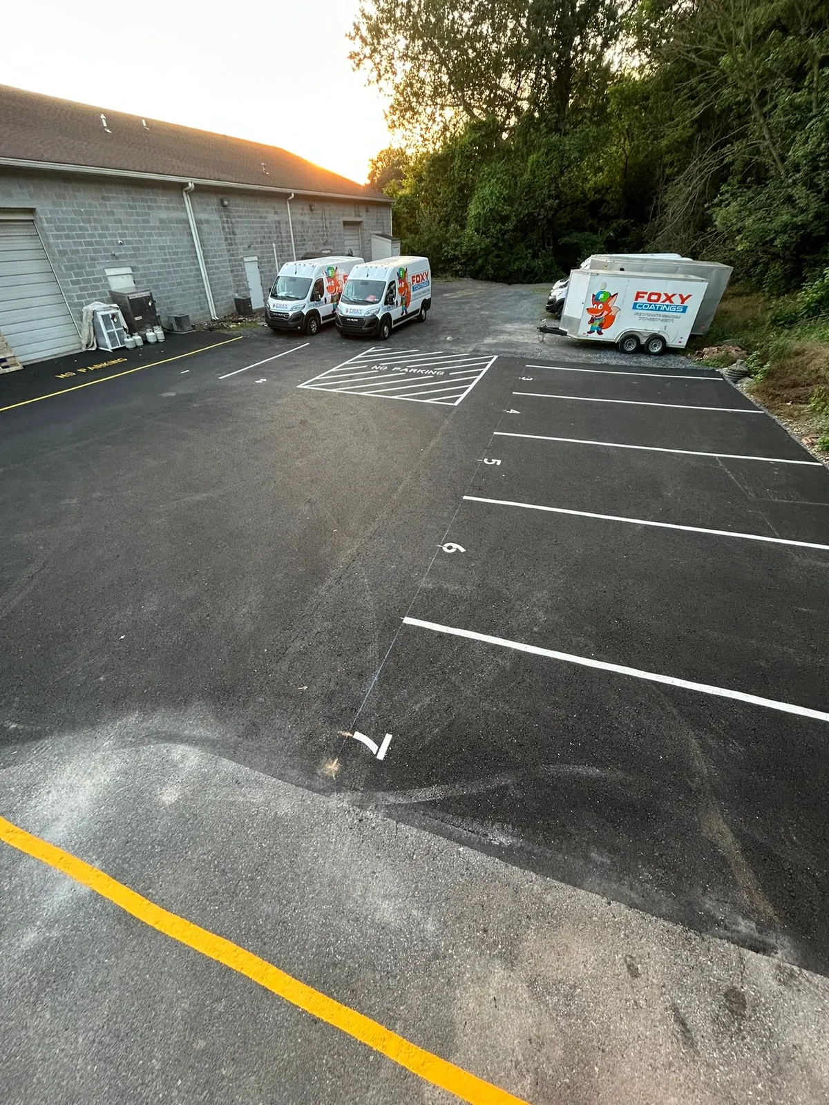Fresh stall lines and yellow curb marking on repaired asphalt