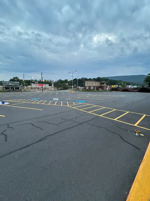 Freshly painted yellow stall lines across a large retail parking lot