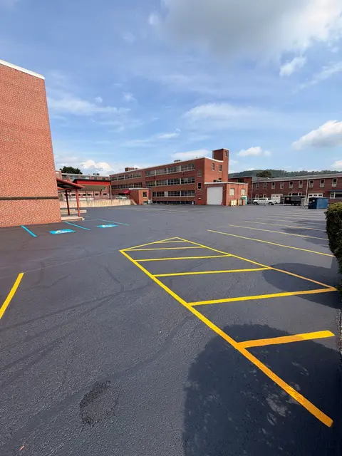 Yellow hatched aisle and stalls with a blue ADA stall by a brick building
