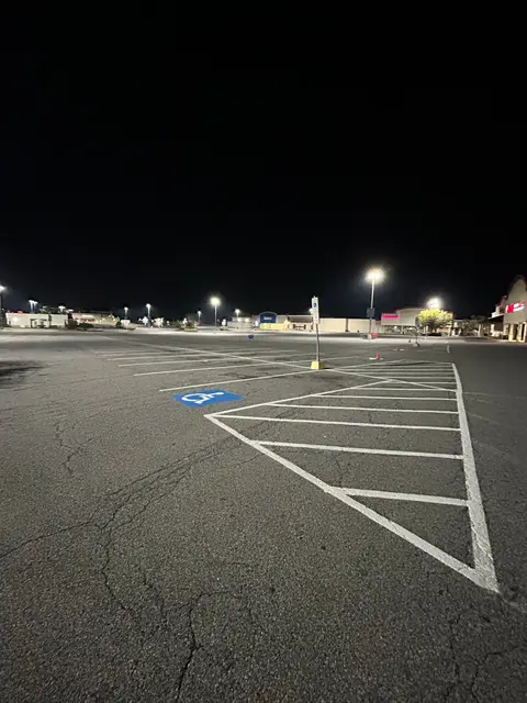Hatched ADA access aisle in a shopping center lot at night