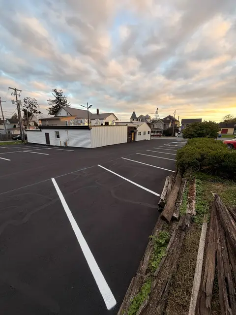 Small parking lot re-striped with white stall lines at sunset